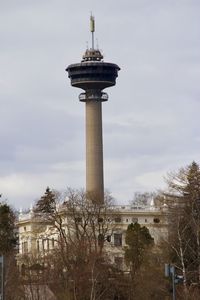 Low angle view of communications tower in city