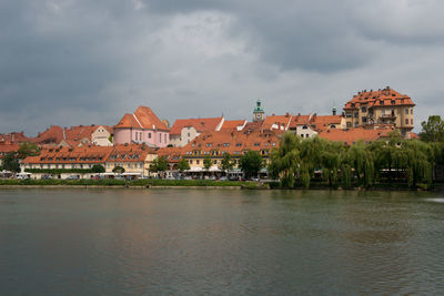 Buildings in town against cloudy sky