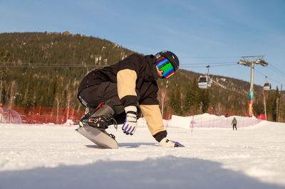 Low section of man skiing on snow covered field