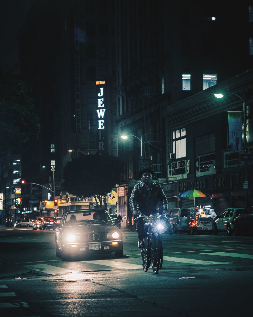 car, land vehicle, transportation, mode of transport, illuminated, city, built structure, street, architecture, night, road, on the move, building exterior, motion, travel, traffic, speed, city life, headlight, city street, blurred motion, rush hour, wet, riding, outdoors, crossroad, tail light