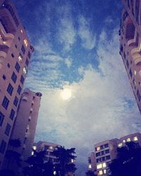 Buildings in city against cloudy sky