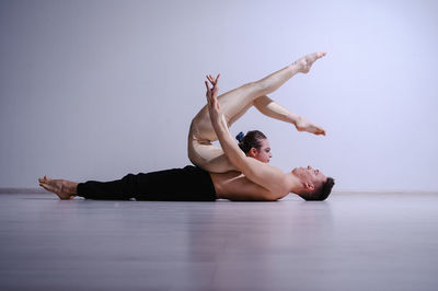 Young man lying on floor against white background