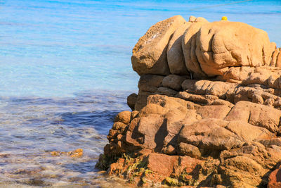 Rock formation on beach against sky