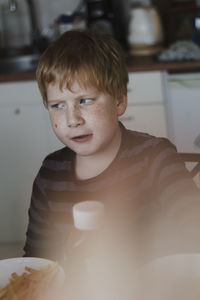 Portrait of boy sitting at home