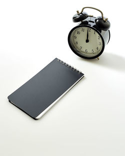 Close-up of clock on table against white background