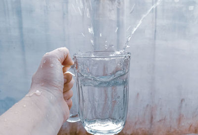 Hand holding glass of water