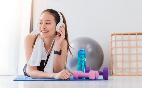 Smiling young woman using mobile phone at home