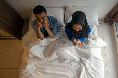 People relaxing on bed at home