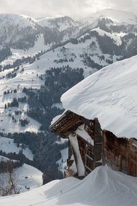 Scenic view of snow covered mountains against buildings