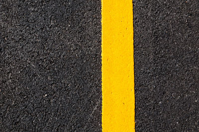 High angle view of yellow arrow sign on road