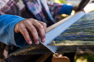 Midsection of man working in loom