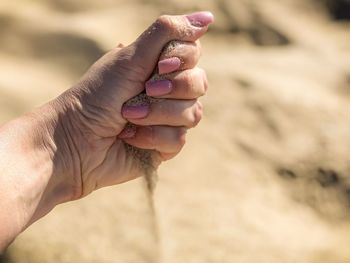 Close-up of hand holding sand