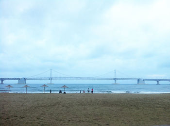 Gwangan bridge over sea against cloudy sky