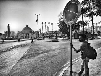 Man standing on street against buildings in city