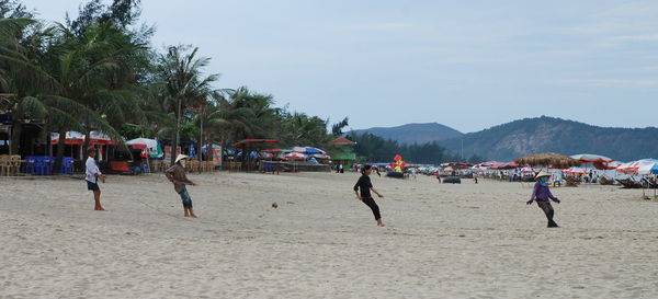 People pulling rope on beach