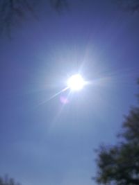 Low angle view of sun shining in sky