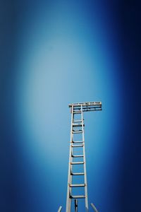 Low angle view of communications tower against clear blue sky