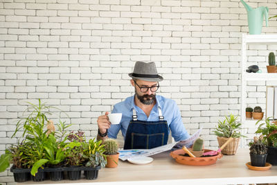 Portrait of senior man holding potted plant