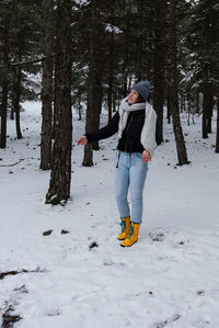 Young happy smiling woman play at snow in the forest. winter at troodos mountains cyprus