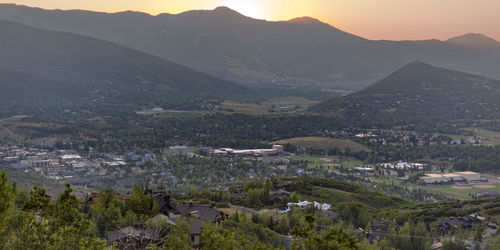 Aerial view of townscape and mountains against sky