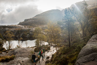 Panoramic shot of people standing on rock against sky