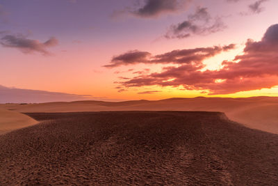 Scenic view of desert against sky during sunset