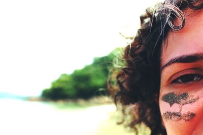 Close-up portrait of young woman with sands on face