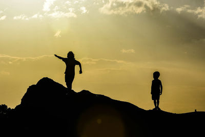 Silhouette people playing against sky during sunset