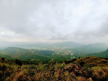 Scenic view of field and mountains against sky