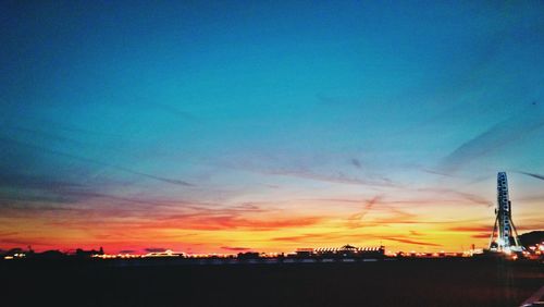 Silhouette of buildings against cloudy sky at sunset