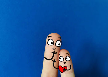 Close-up of hand against blue background