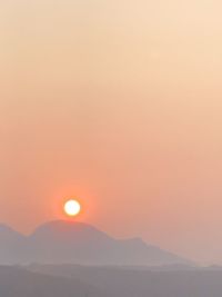 Scenic view of mountains against orange sky