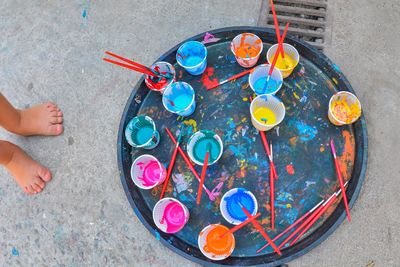 Low section of child with watercolors in disposable cups