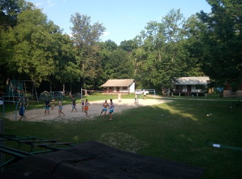 People playing in park against sky