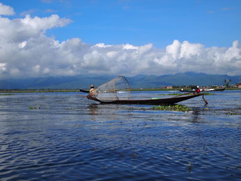 Fishing boat in sea against sky