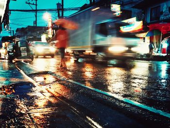 People on illuminated railroad tracks in city