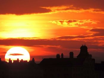 Silhouette of building against dramatic sky