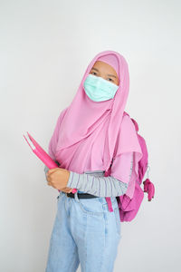 Portrait of woman with pink hair against white background