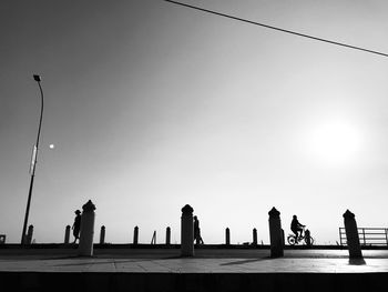 Low angle view of people on street against clear sky