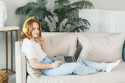 Portrait of woman sitting on sofa at home