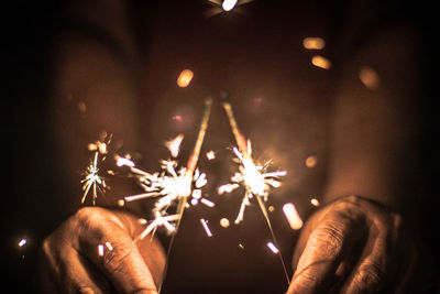 Close-up of hand holding illuminated firework display