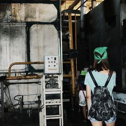 Rear view of woman standing in factory