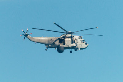 Low angle view of airplane against clear blue sky