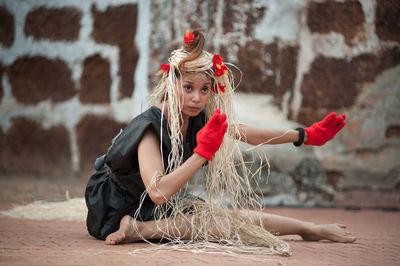 Young woman wearing mask against wall