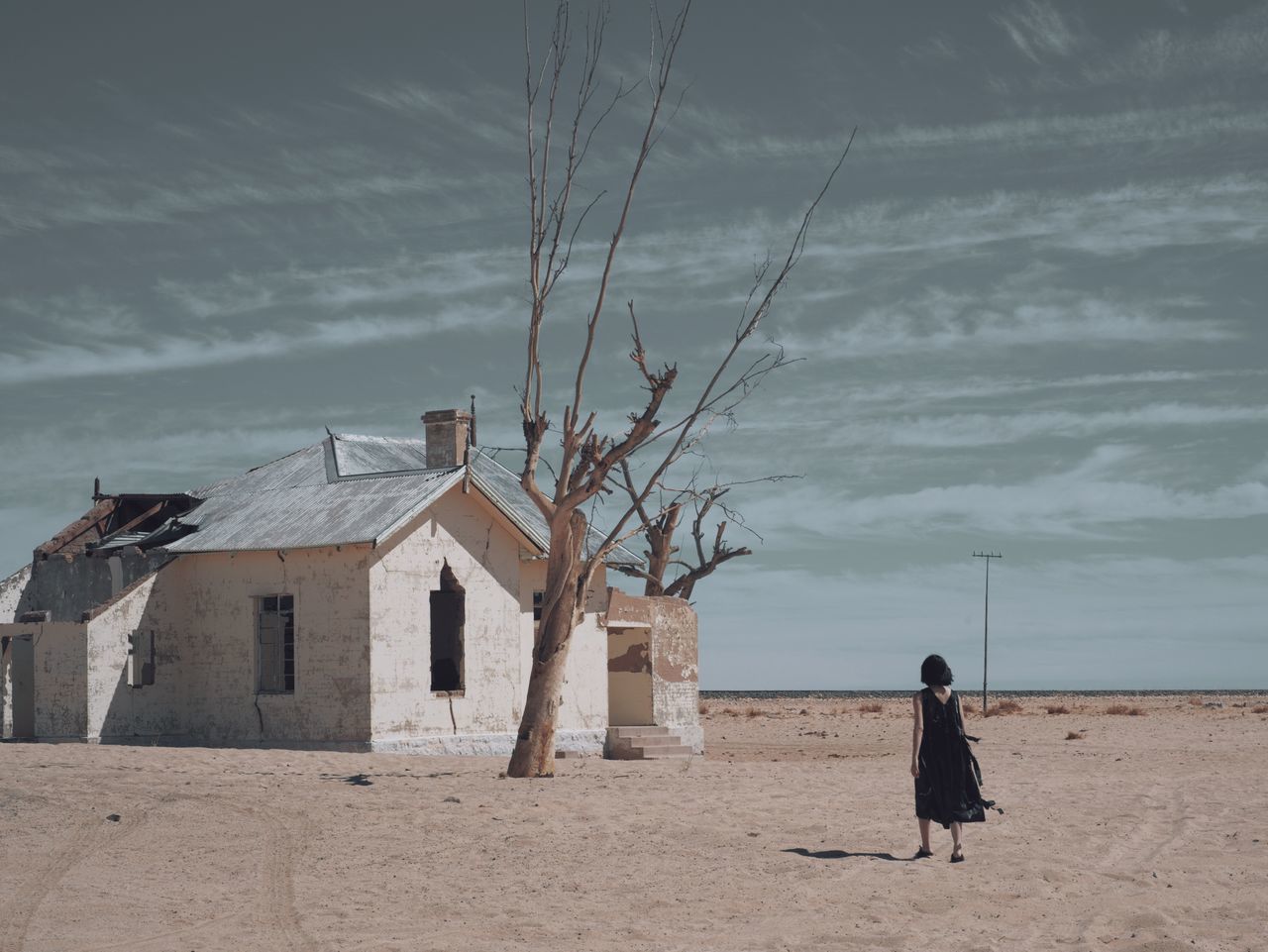 built structure, architecture, building exterior, cloud - sky, land, sky, building, nature, beach, sand, one person, standing, real people, house, rear view, lifestyles, day, outdoors, walking