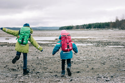 Siblings hiking together by the water in northern sweden