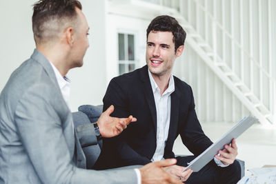 Smiling businessman discussing over document at office