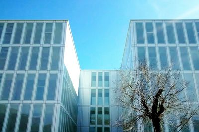 Low angle view of office building against blue sky