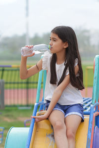 Girl drinking water at playground