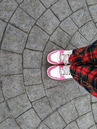 Low section of woman standing on footpath